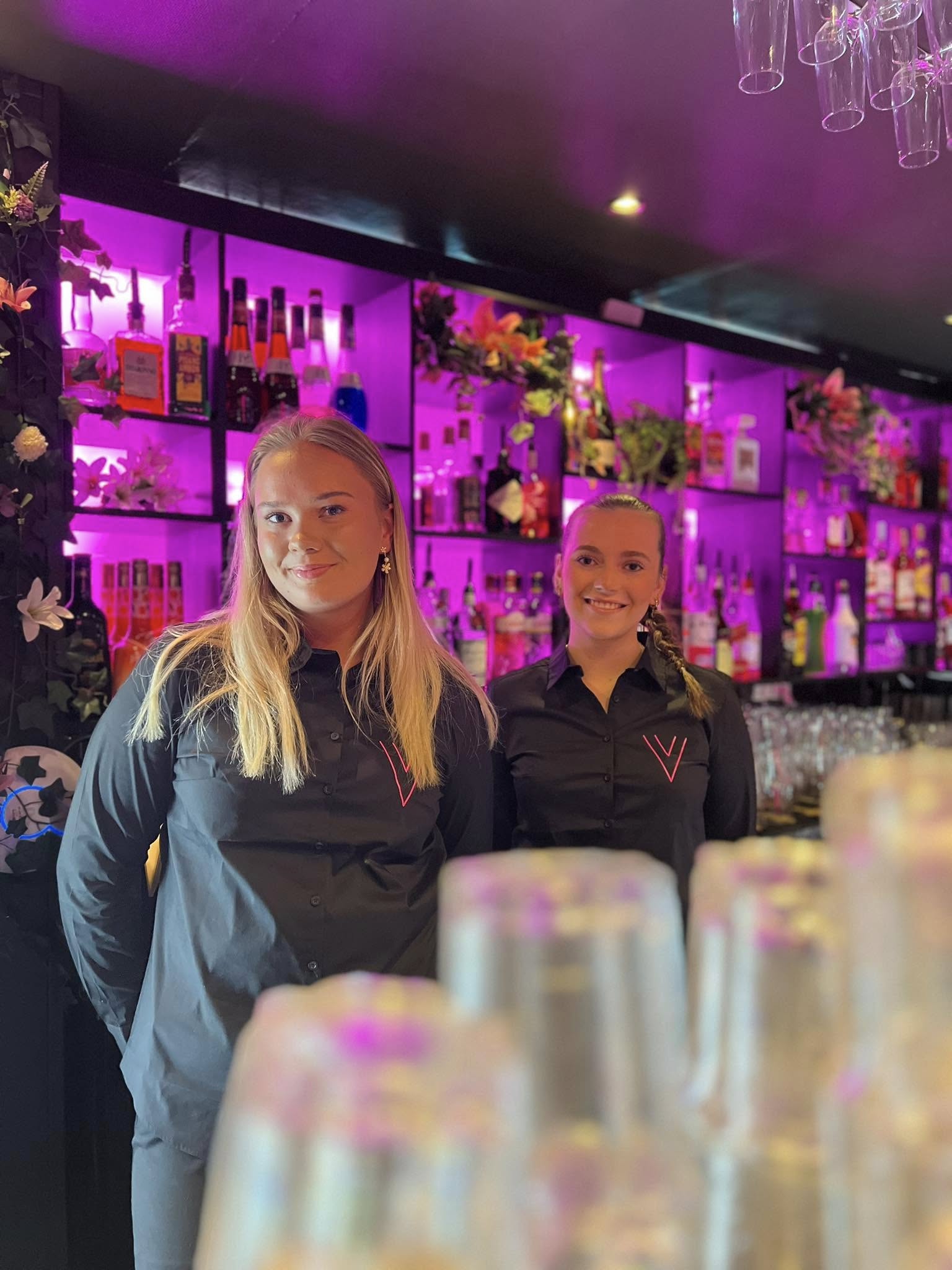 Bartendere med V-broderte skjorter og lilla bar